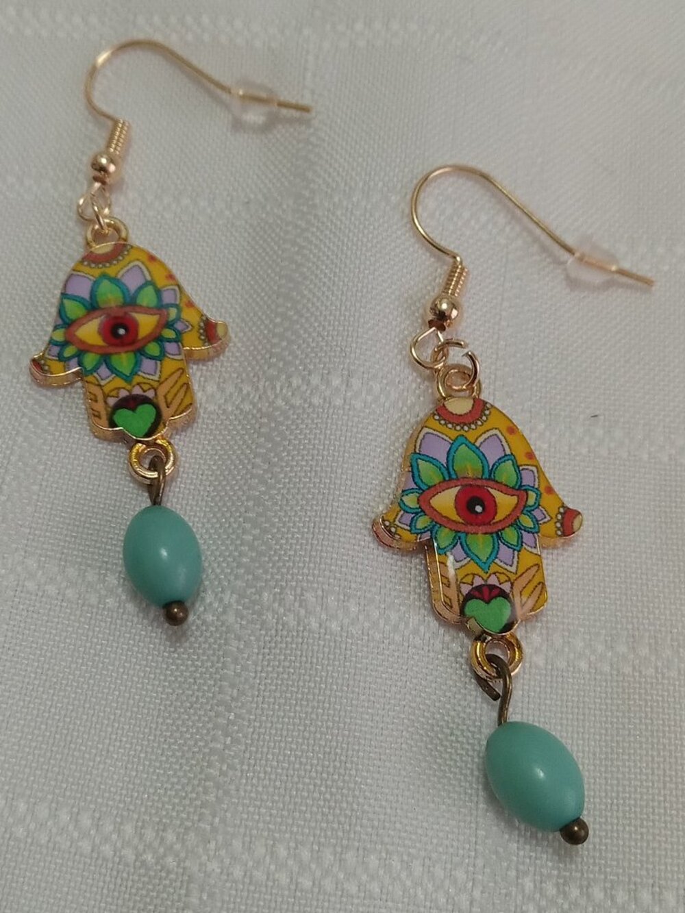 Handmade gold-colored earrings with multicolored enameled fatima hands and beads